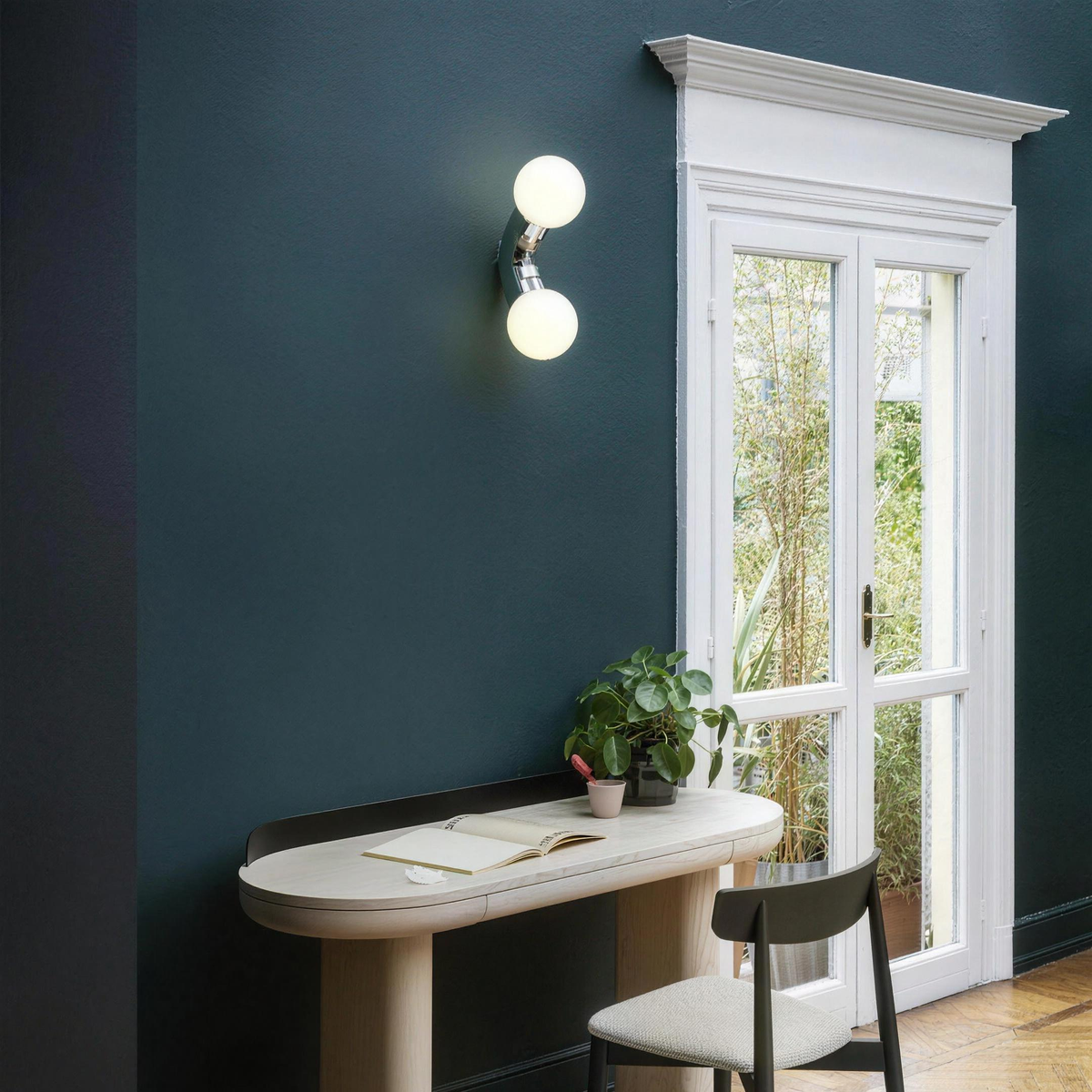 Como wall light switched on above a desk on a teal wall - Hestia + Co.
