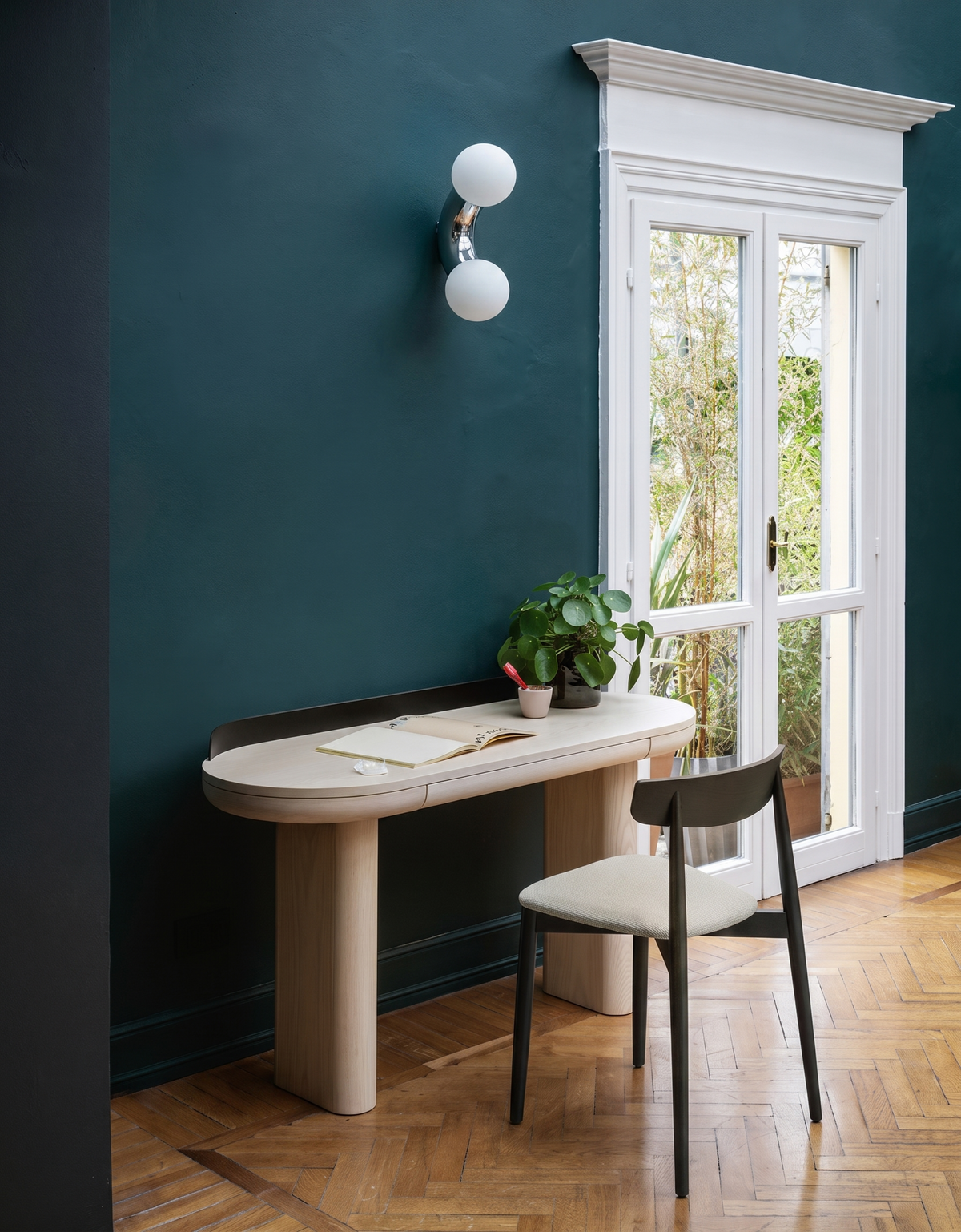 Como wall light switched off above a desk on a teal wall - Hestia + Co.